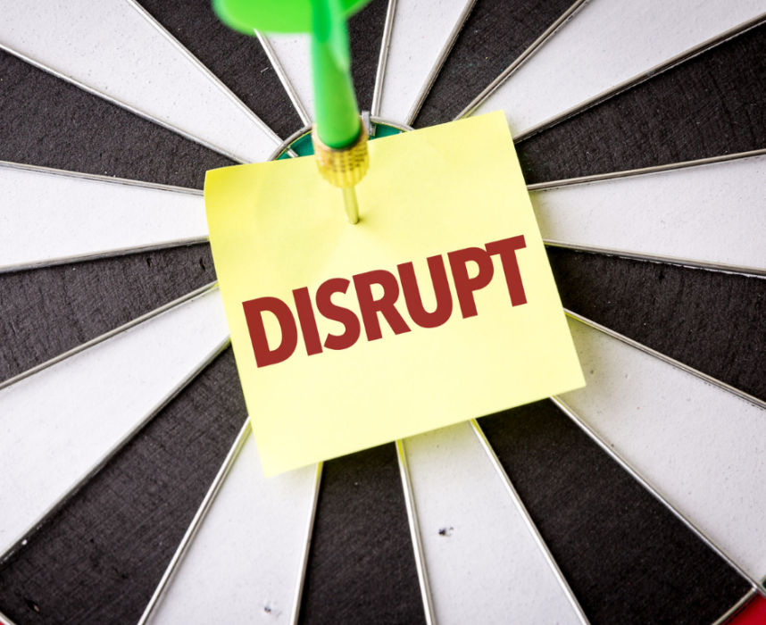 dart going through a post it with the word disrupt on it.